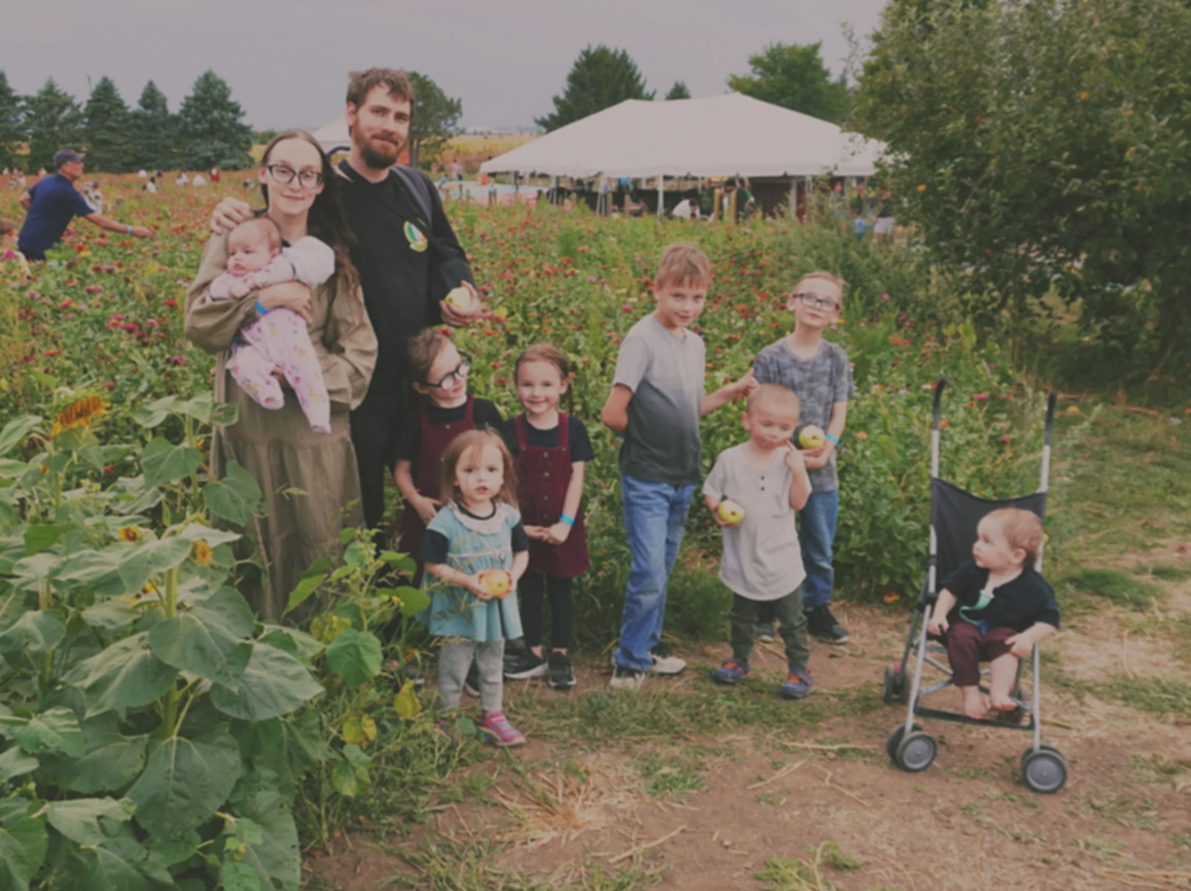 The Pietrzak family together in a flower and sunflower garden